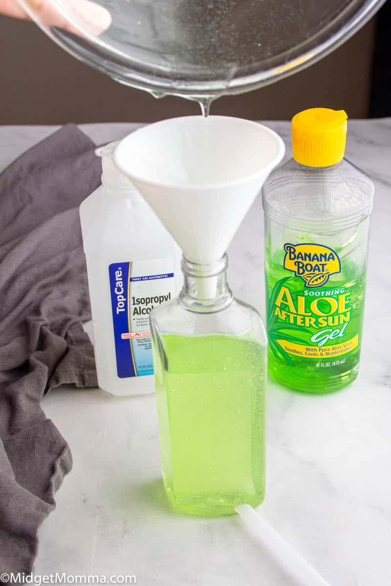 pouring homemade hand sanitizer into the pump bottle with a funnel