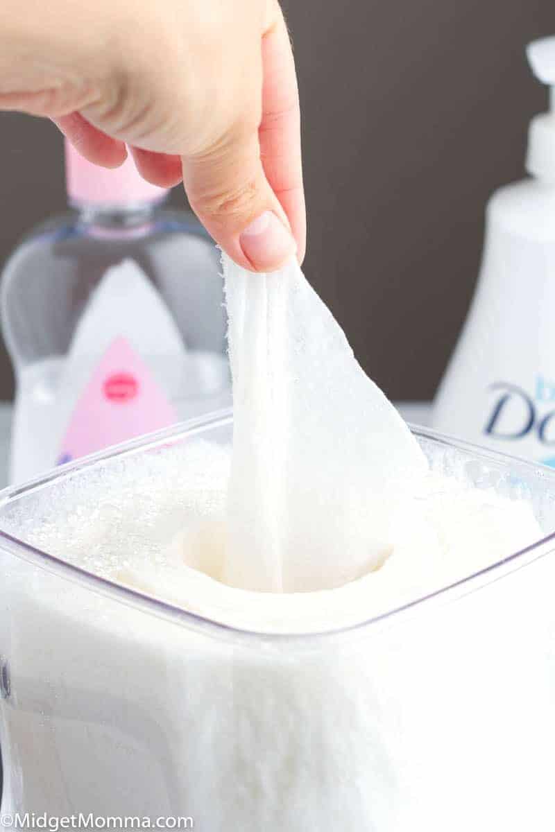 Homemade baby wipes in a container being pulled out