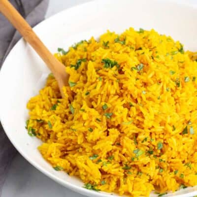 Instant Pot Turmeric Rice in a white bowl with a wooden spoon