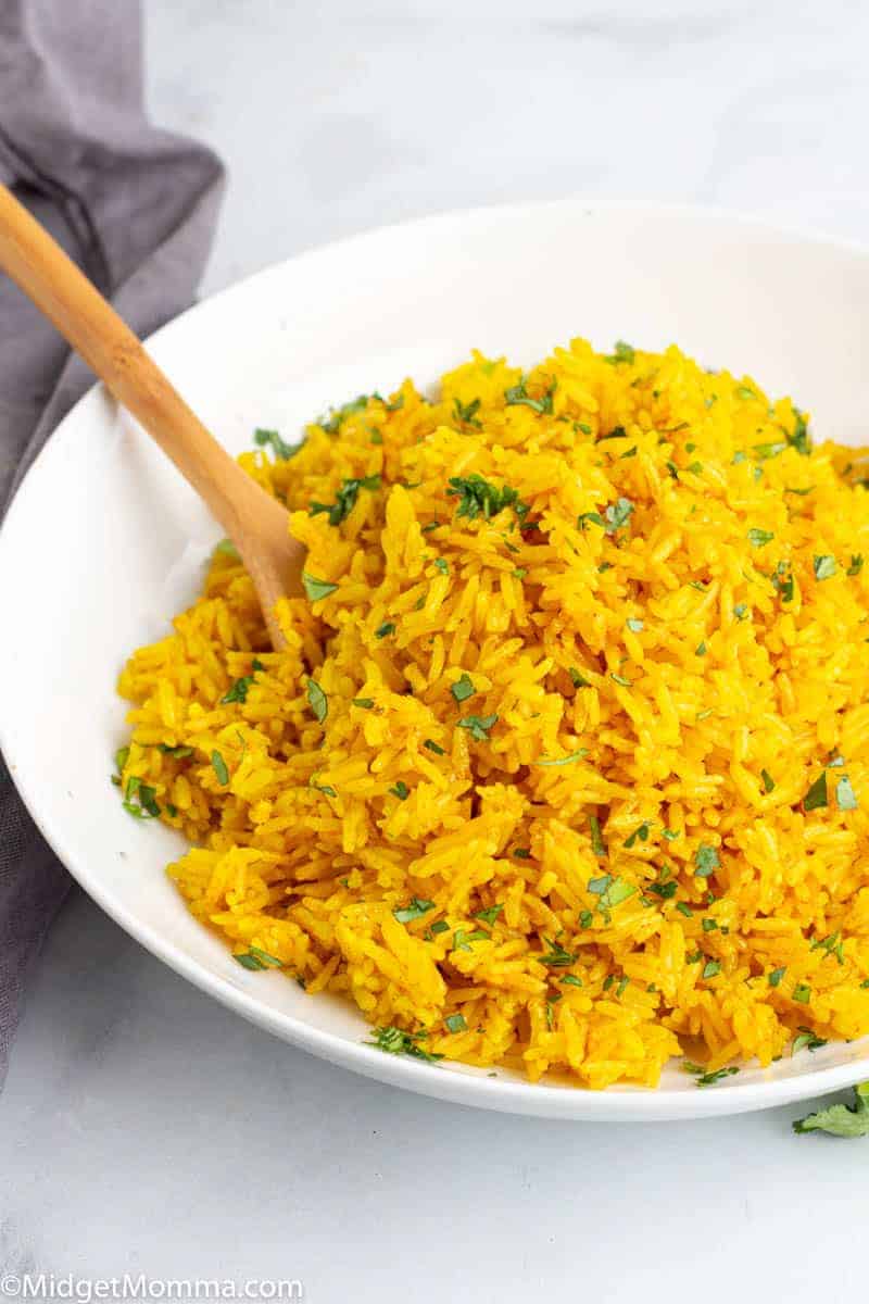 Instant Pot Turmeric Rice in a white bowl with a wooden spoon