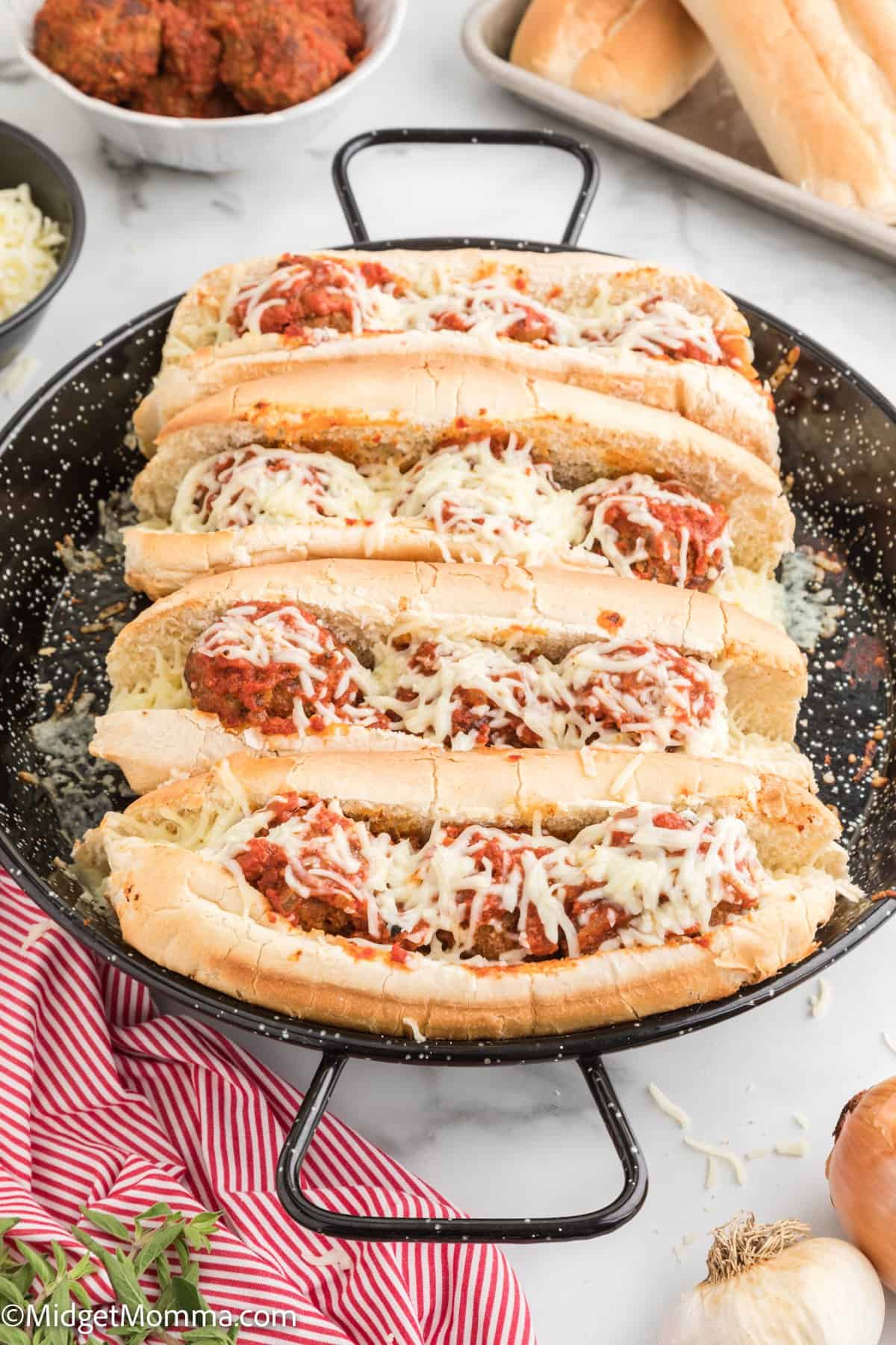 close up photo of 4 meatball subs with marinara sauce and shredded mozzarella cheese