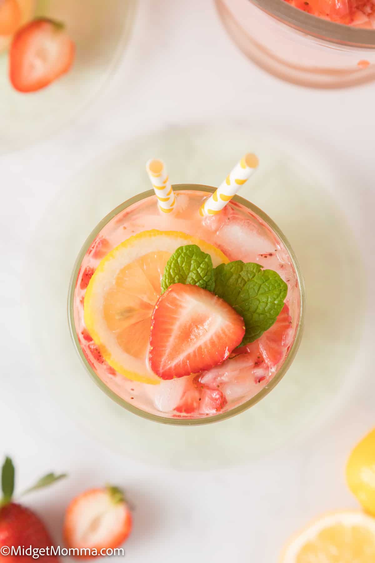 overhead photo of a glass of strawberry lemonade with a pile of strawberries