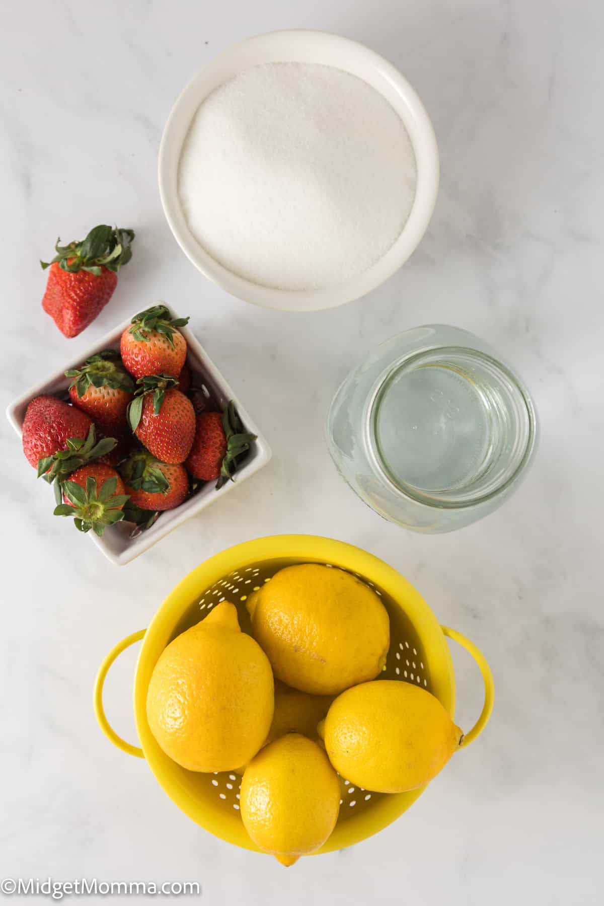 Homemade Strawberry Lemonade Recipe ingredients - bowl of lemons, bowl of strawberries, bowl of sugar and water