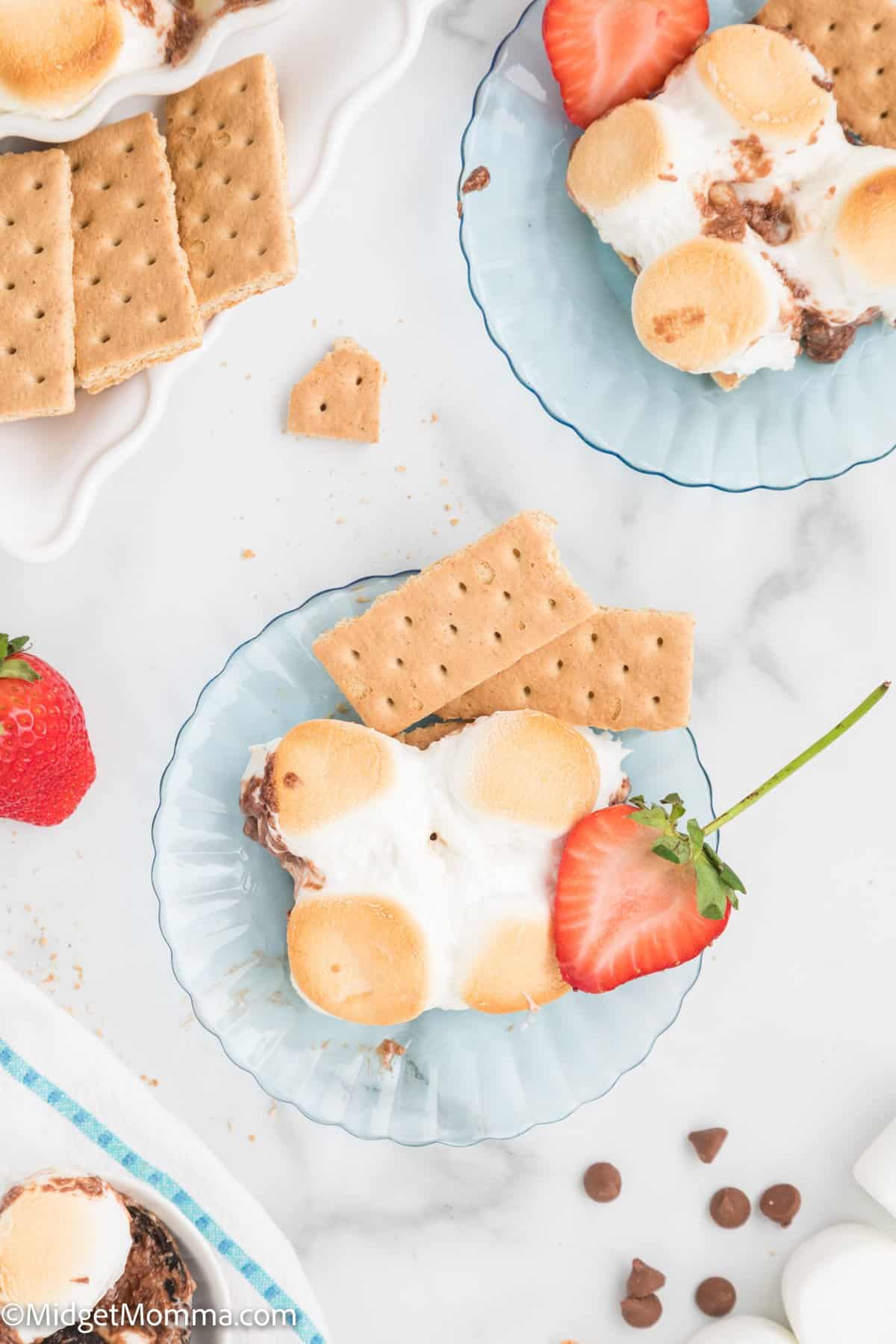 Baked S'mores dip on a plate with strawberries and cookies
