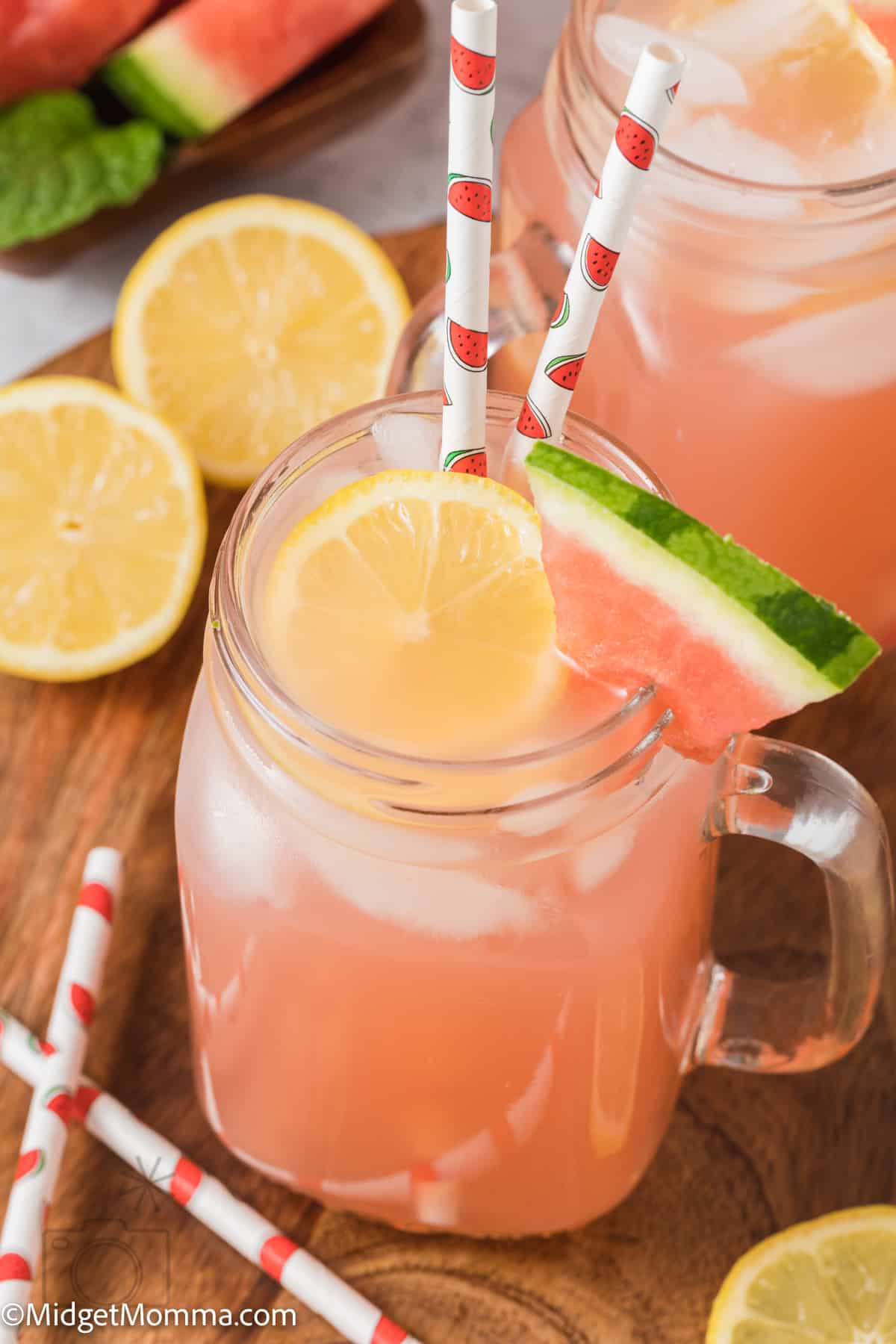 mason jar glass filled with Homemade pink Watermelon Lemonade and a slice of watermelon on the edge of the glass 