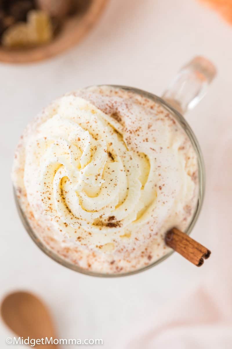 overhead photo of pumpkin spice latte with whipped cream in a glass