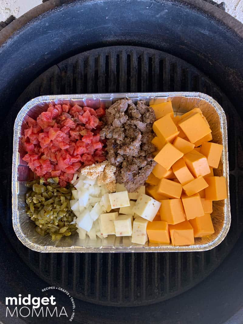 Smoked Queso Dip ingredients in a pan on the grill