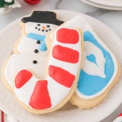 A plate of christmas cookies decorated with snowflakes and candy canes.