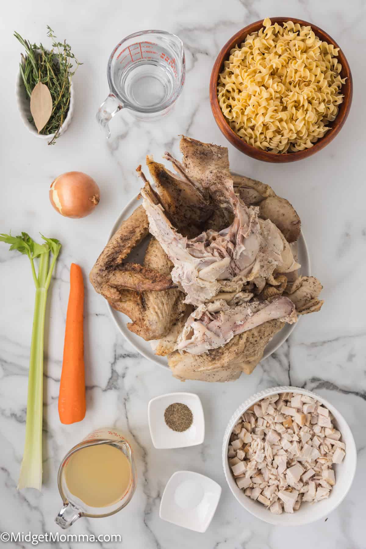Ingredients for making soup arranged on a marble surface: cooked poultry bones, cooked poultry meat, pasta, carrot, celery, onion, herbs, broth, water, salt, and pepper.