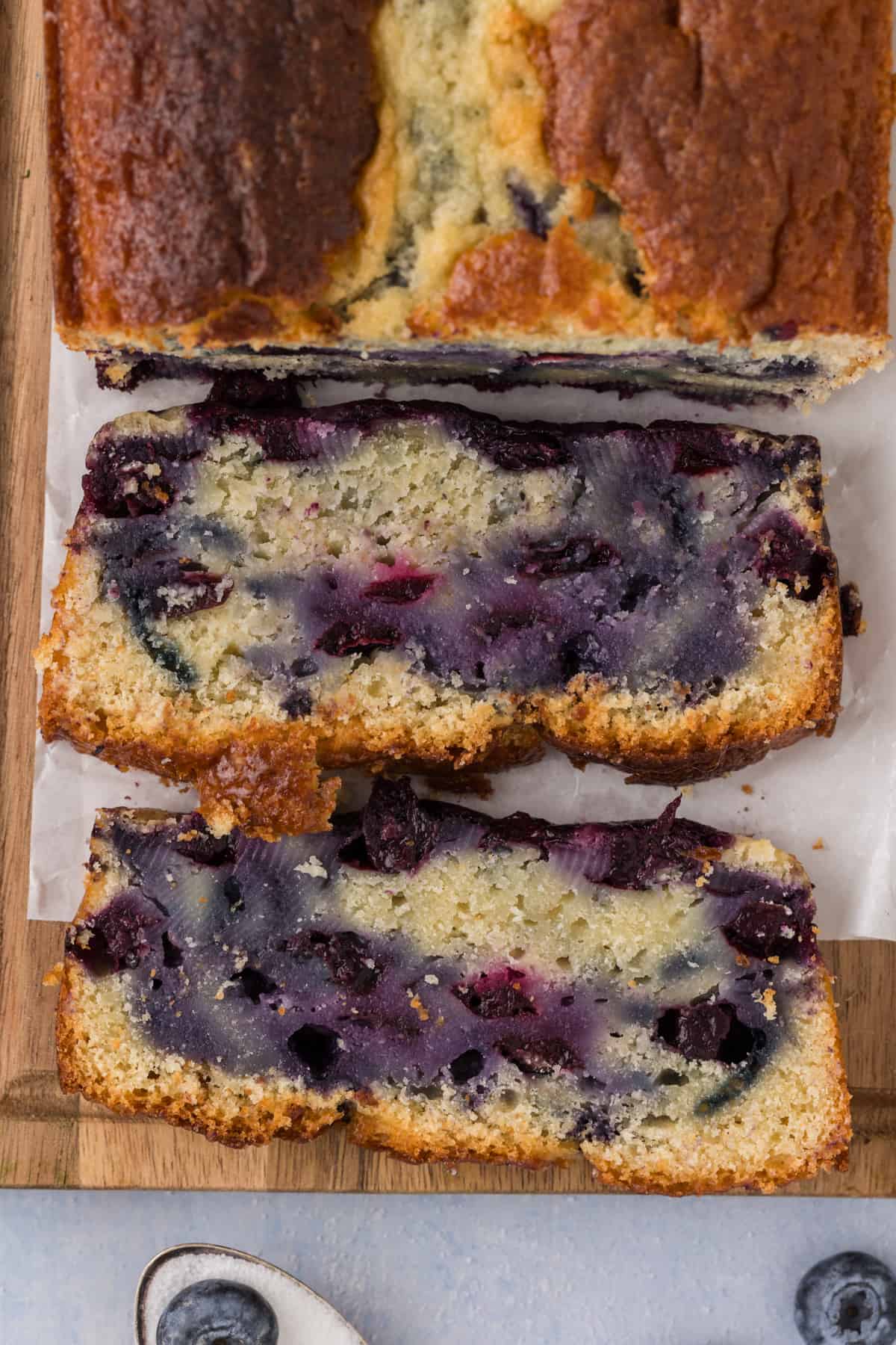 A slice of blueberry bread on a cutting board.