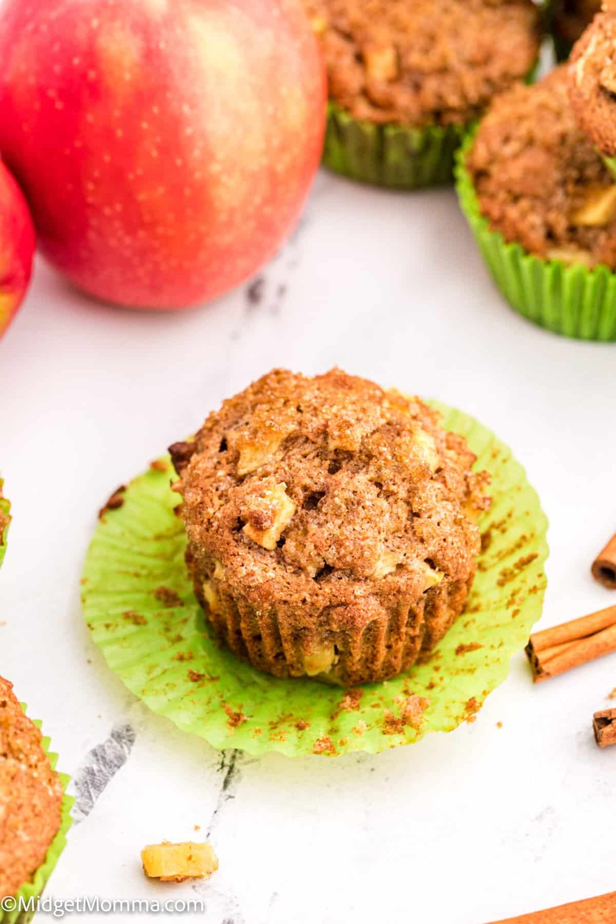 apple cinnamon muffin with a muffin wrapper under it