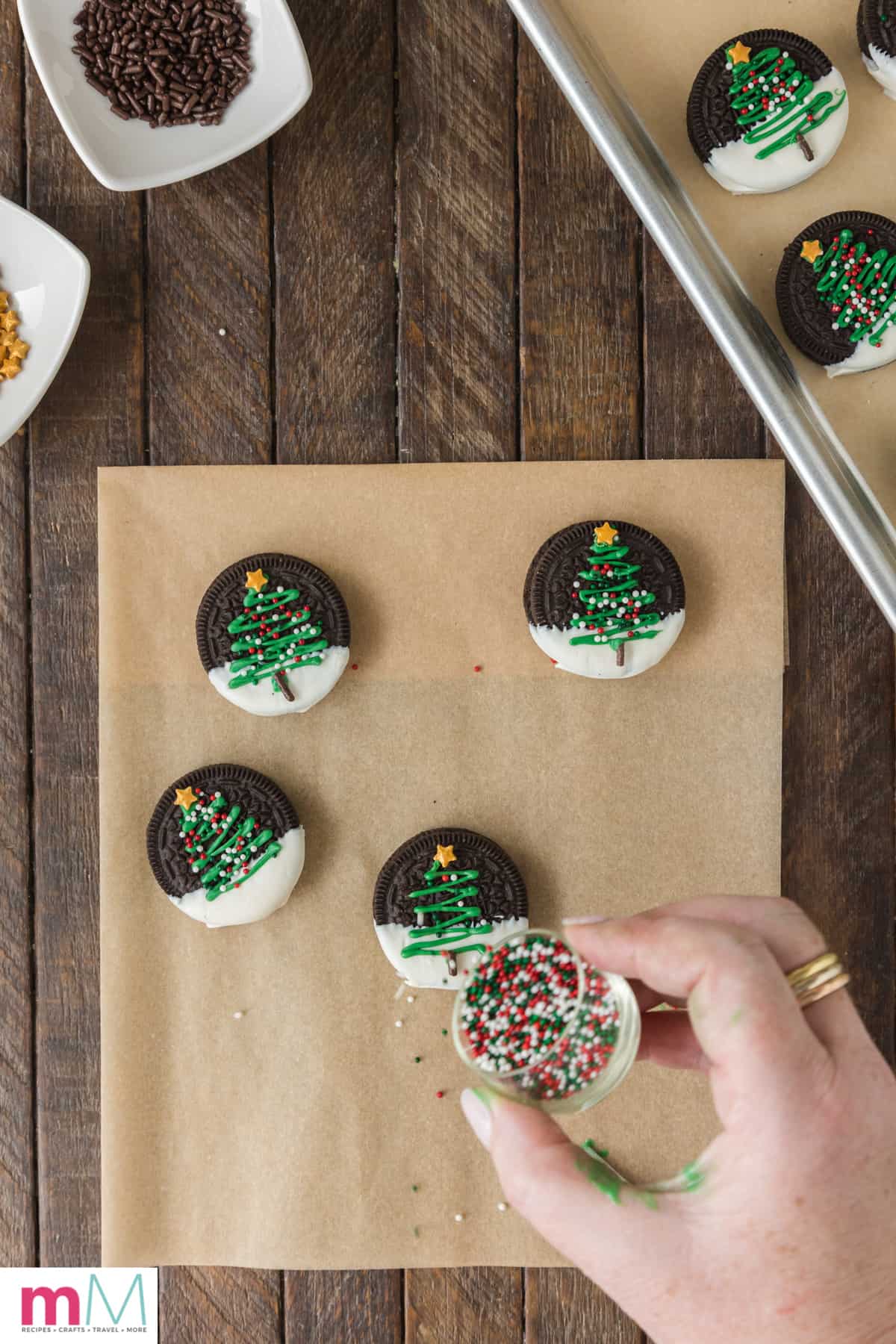 small ball sprinkles being added to christmas tree oreo cookies