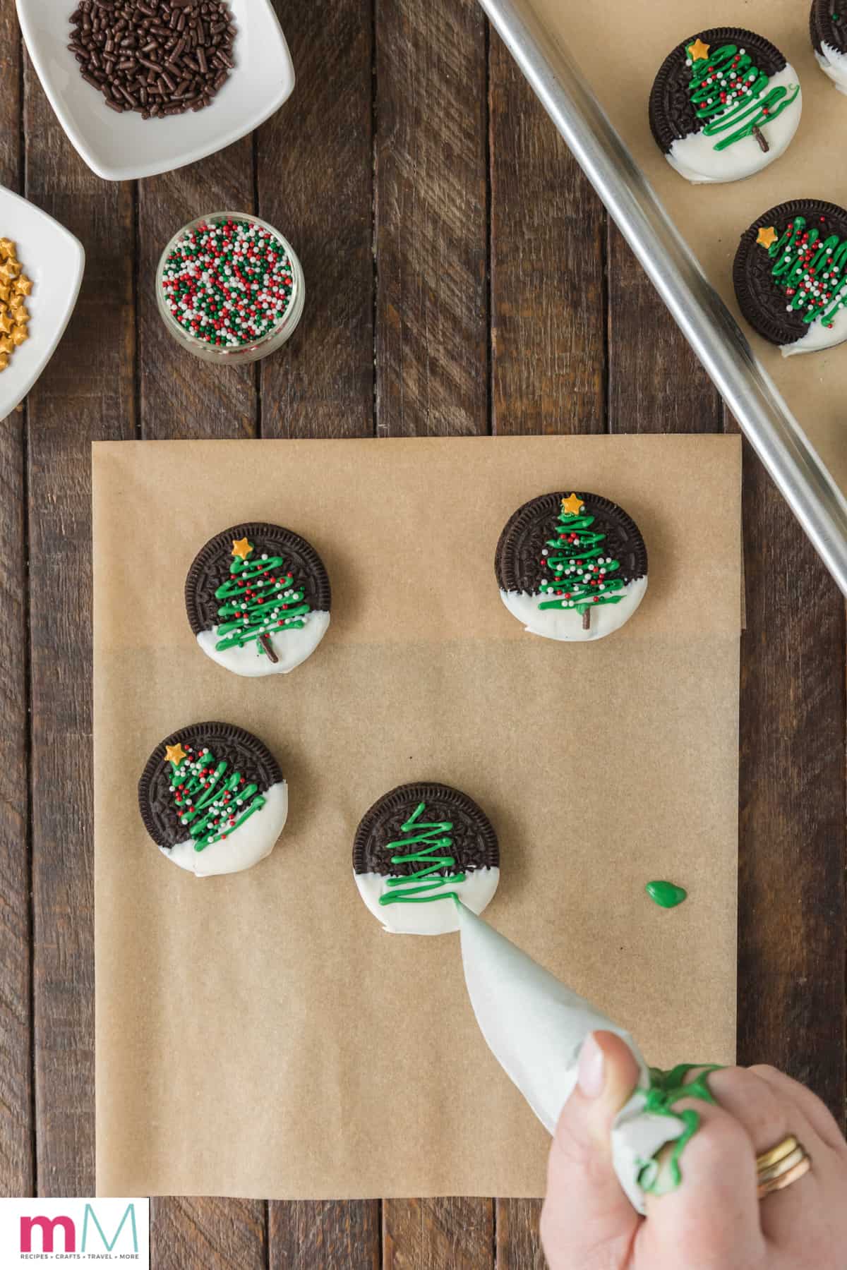 melted chocolate tree being drawn on christmas oreo cookies