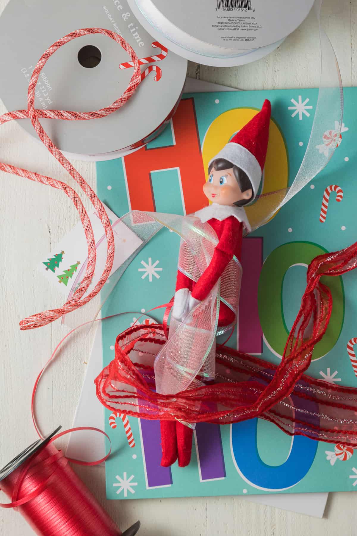Elf on the shelf tangled in christmas decorations