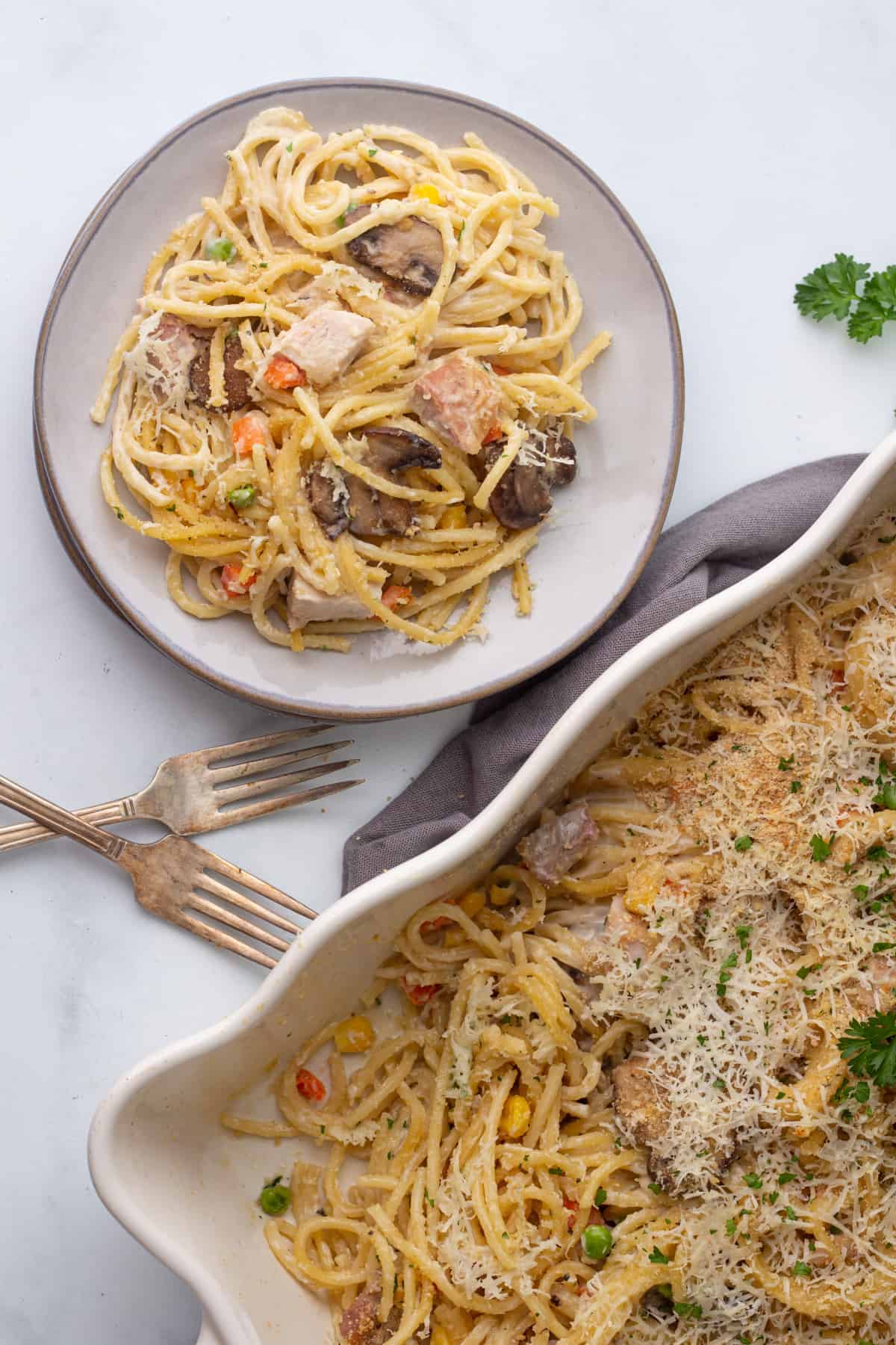 A casserole dish with pasta, turkey and parsley.