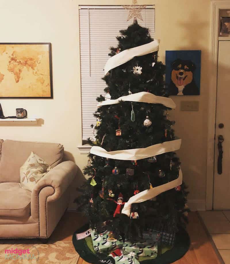 A christmas tree decorated with ribbons and bows by elf on the shelf