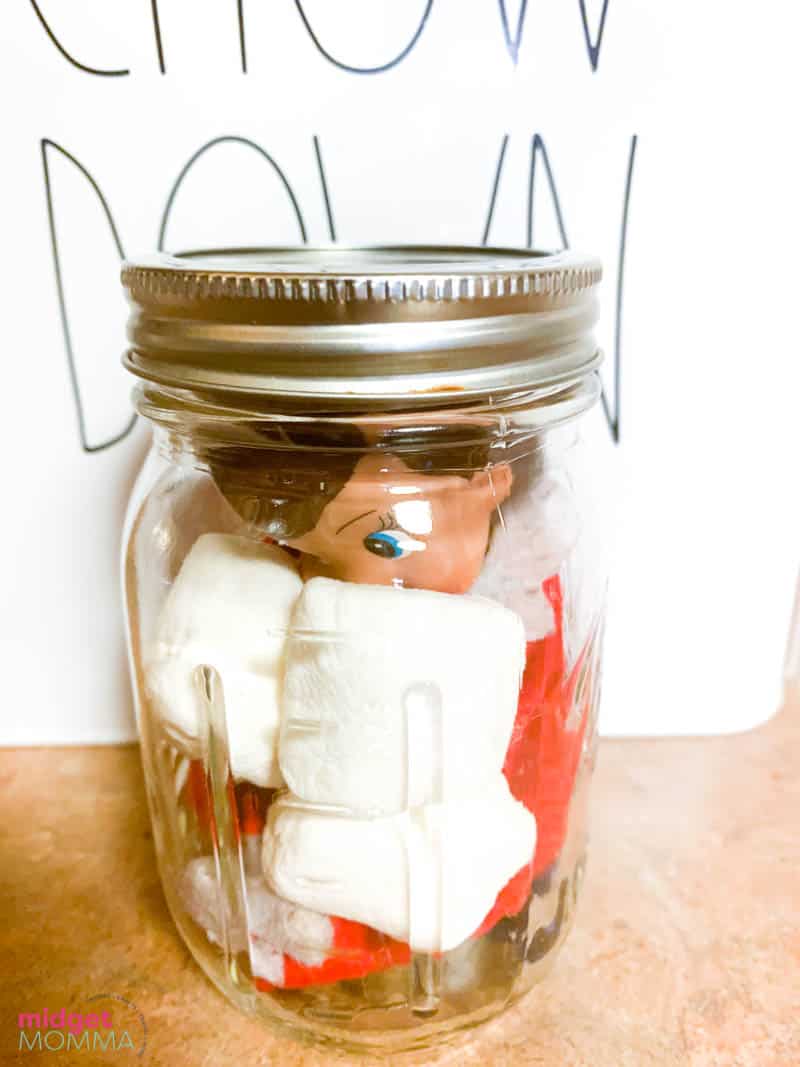 A jar with marshmallows and an elf.