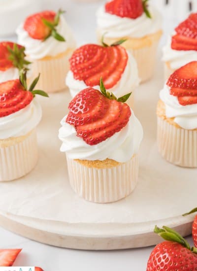 front view of angel food cupcakes topped with whipped cream and strawberries