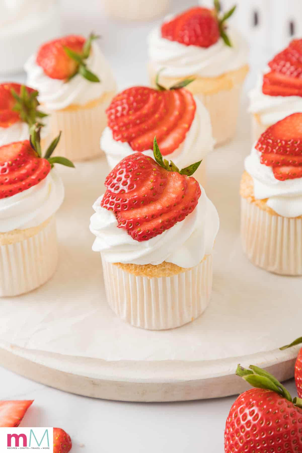 front view of angel food cupcakes topped with whipped cream and strawberries