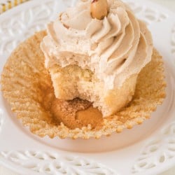 a single peanut butter cupcake on a plate with a bite taken out