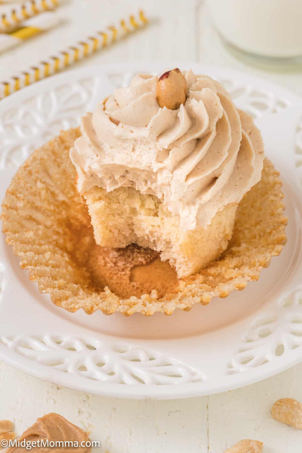 a single peanut butter cupcake on a plate with a bite taken out 