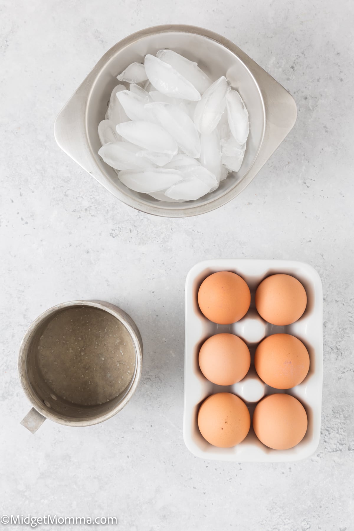 Eggs and ice in a bowl on a white surface.