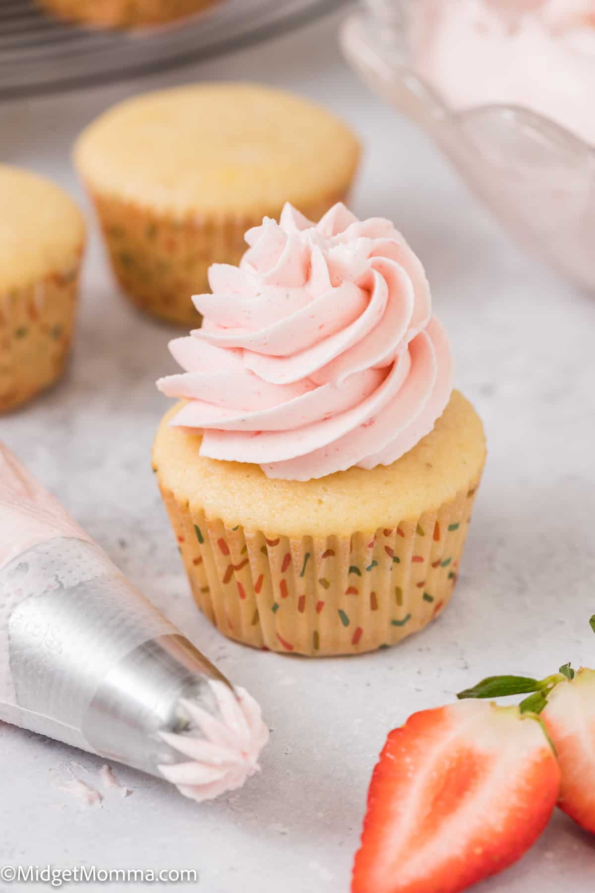 strawberry cupcake topped with strawberry buttercream frosting