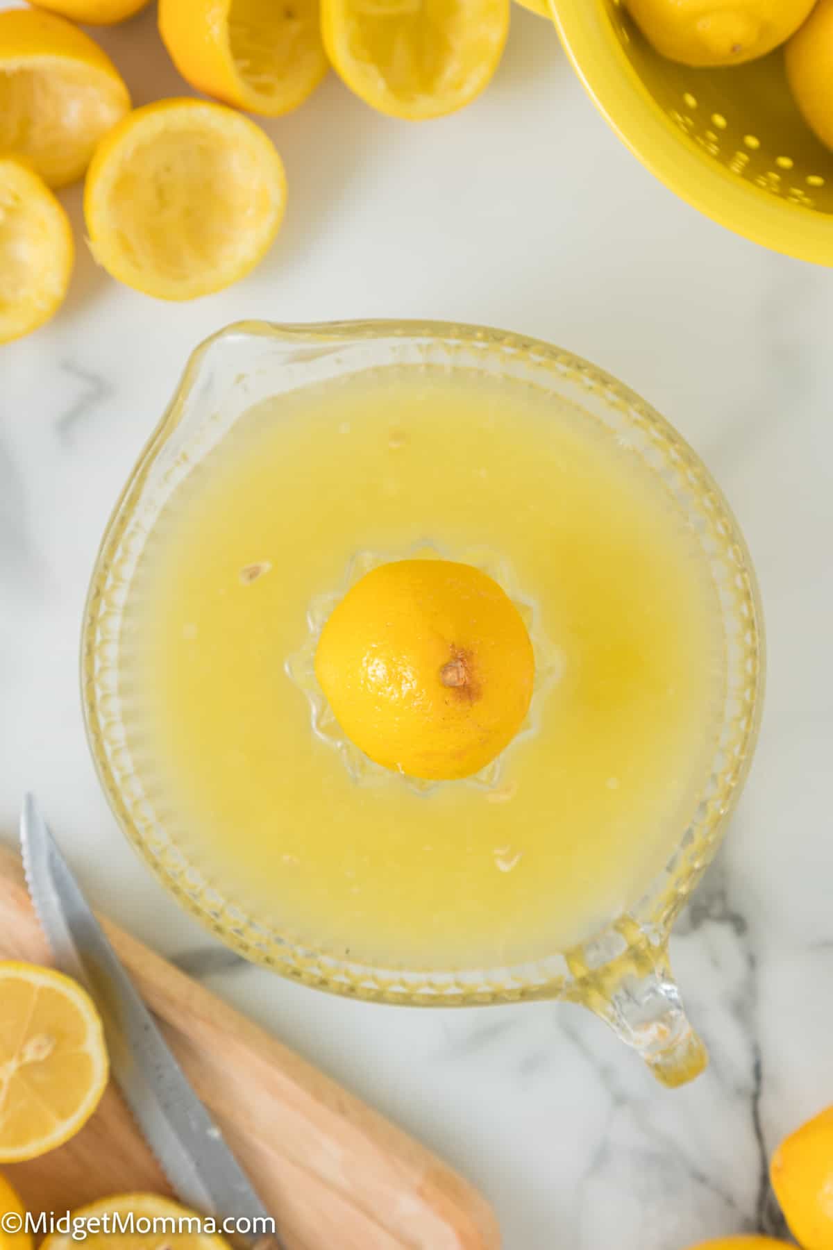 lemon juice being squeezed from a lemon with a lemon juicer