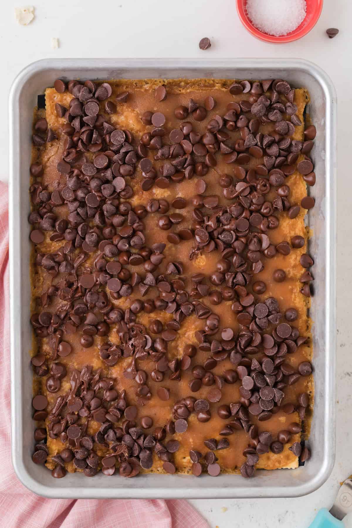 chocolate chips sprinkled on top of crackers with caramel spread on top of them
