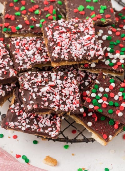 Chocolate saltine cracker candy (Christmas crack recipe) on a plate with red and green sprinkles.