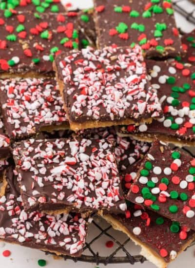 Chocolate saltine cracker candy (Christmas crack recipe) on a plate with red and green sprinkles.