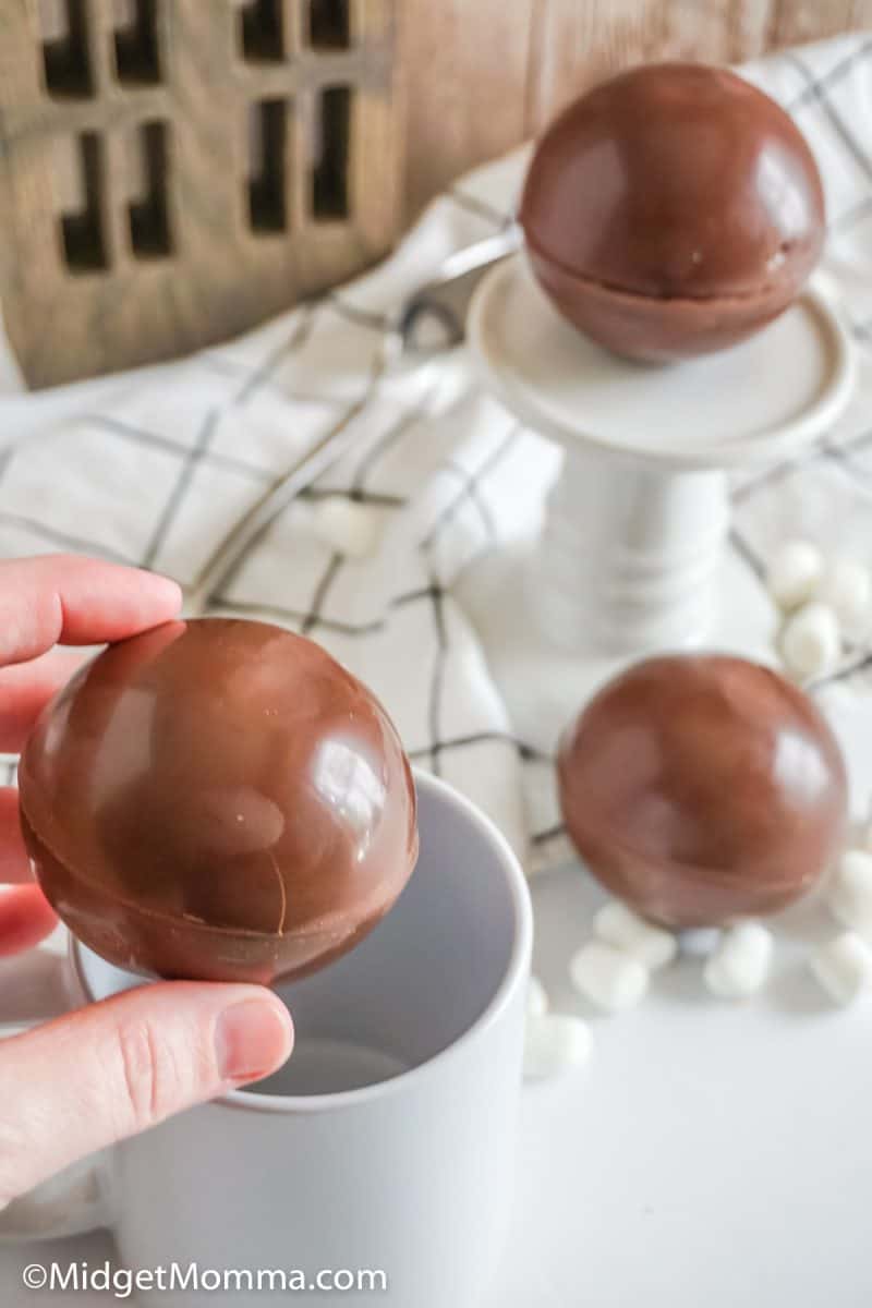 close up photo of hot cocoa bombs in a hand