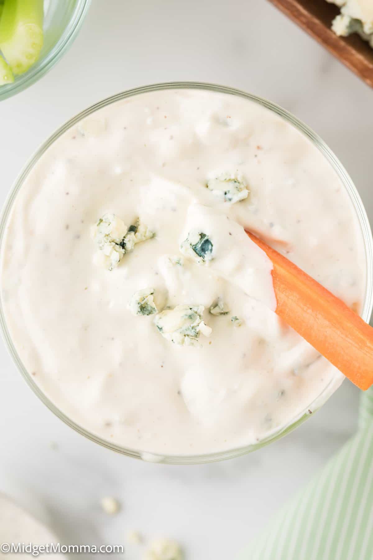bowl of homemade blue cheese dressing with a carrot dipped in.