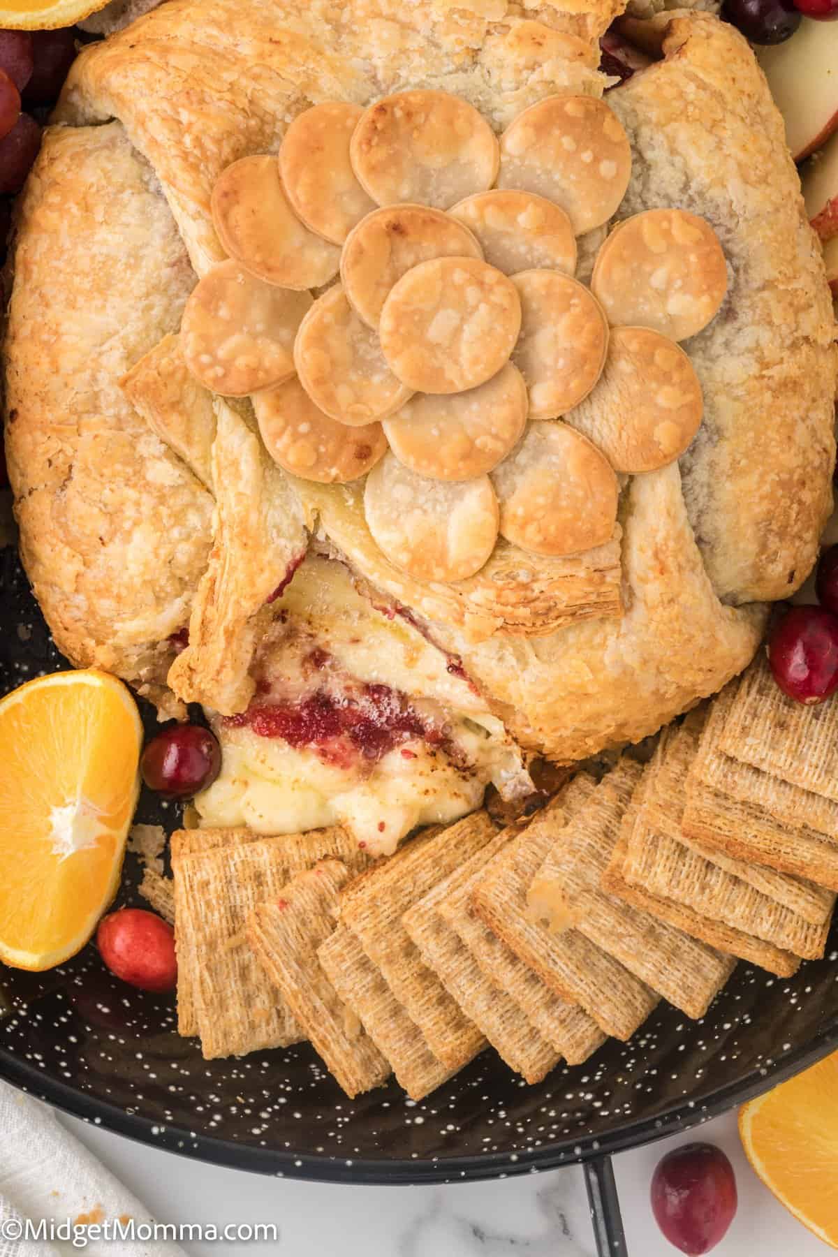 Cranberry Baked Brie on a platter with crackers