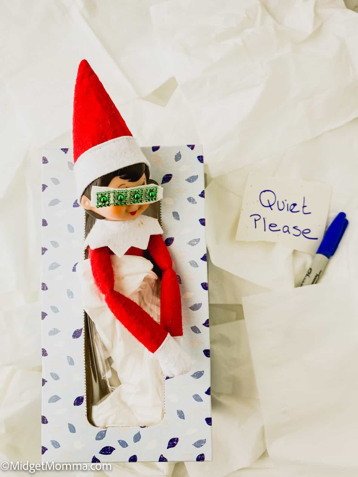 An elf in a box with a sign that says quit please.