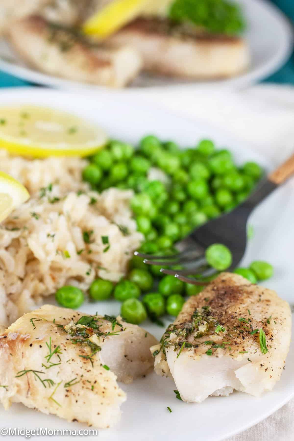 Air Fryer Cod on a plate served with green peas and rice