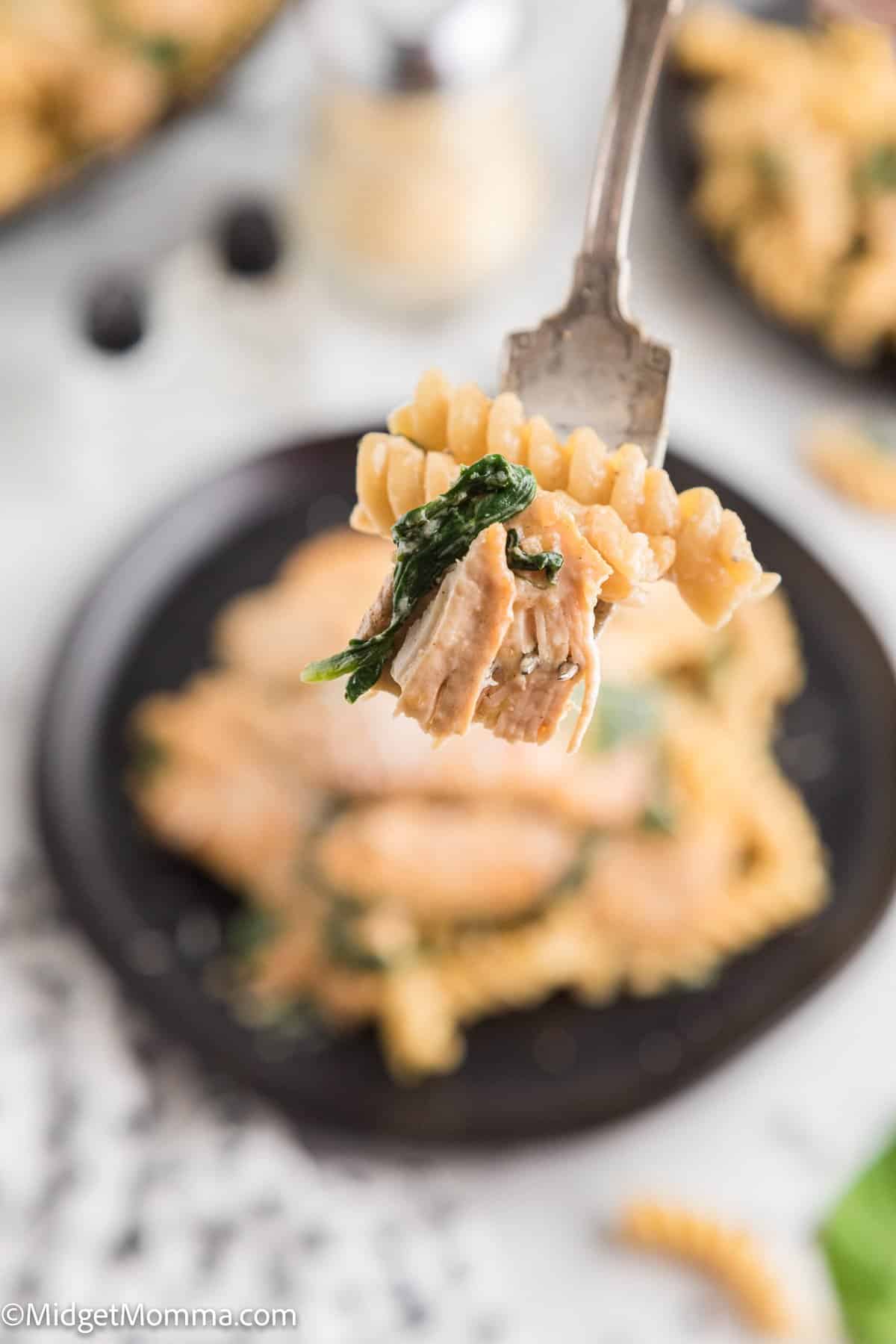 bite of Creamy Garlic chicken pasta with spinach on a fork