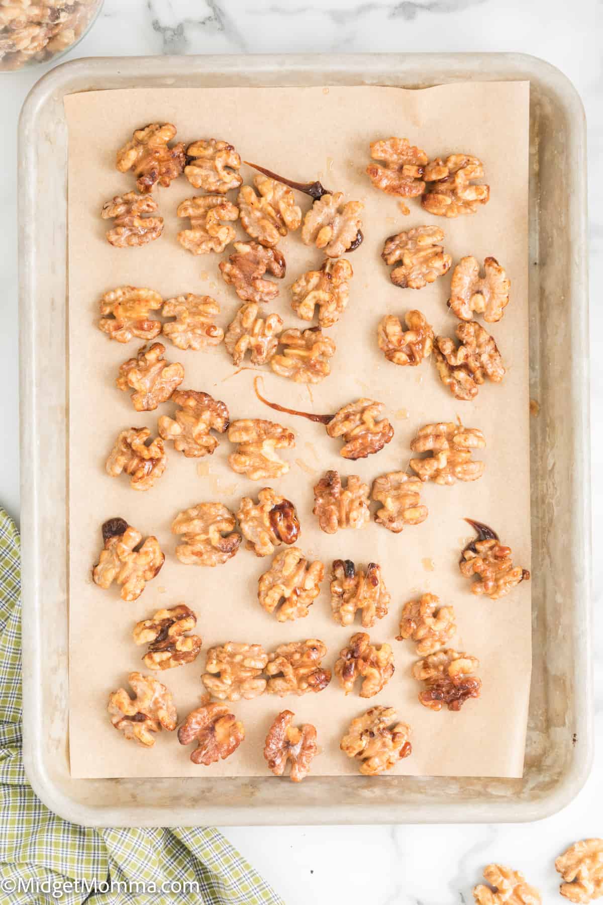 candied walnuts finished cooking cooling on a baking sheet