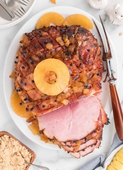 over head photo of baked ham with brown sugar glaze on a serving platter