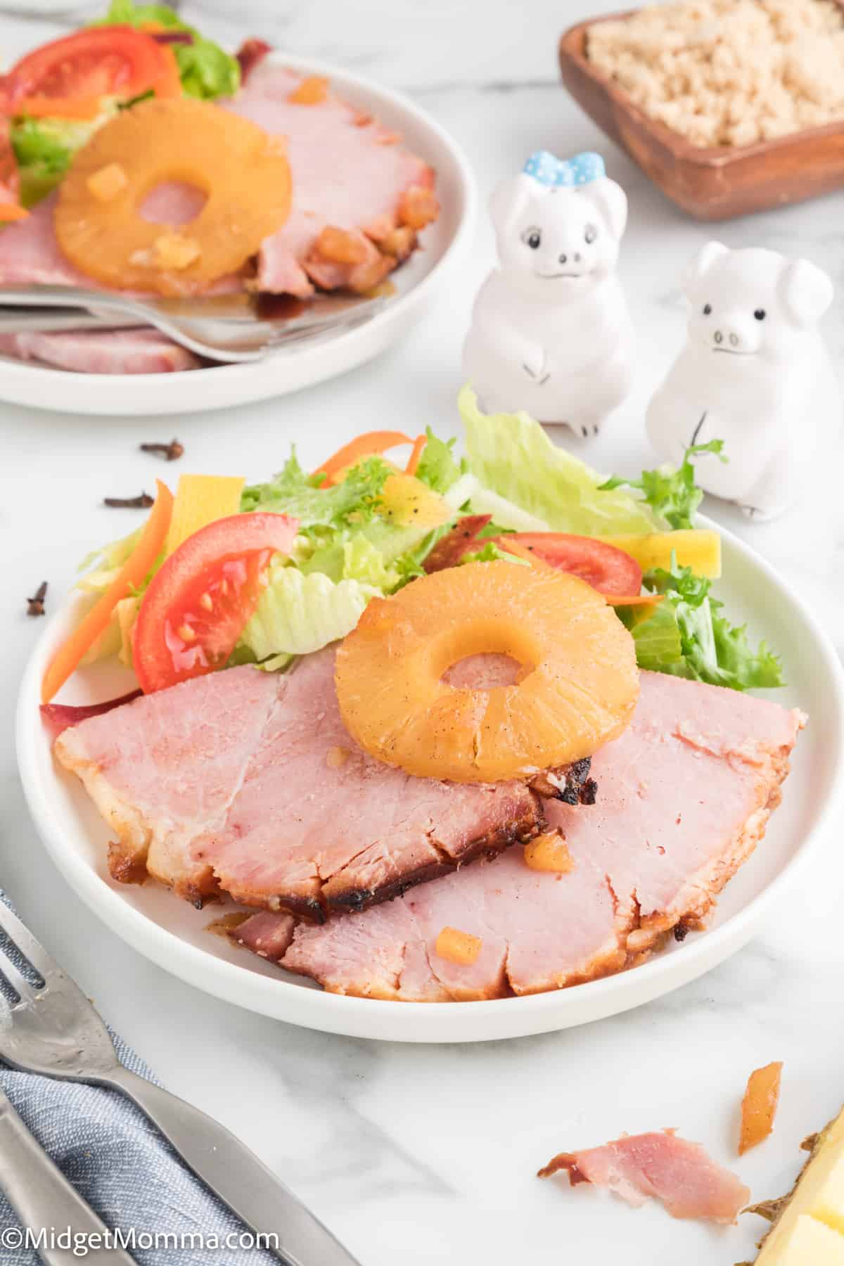 Baked Ham with Pineapple and Brown Sugar Glaze on a plate being served with a fresh salad