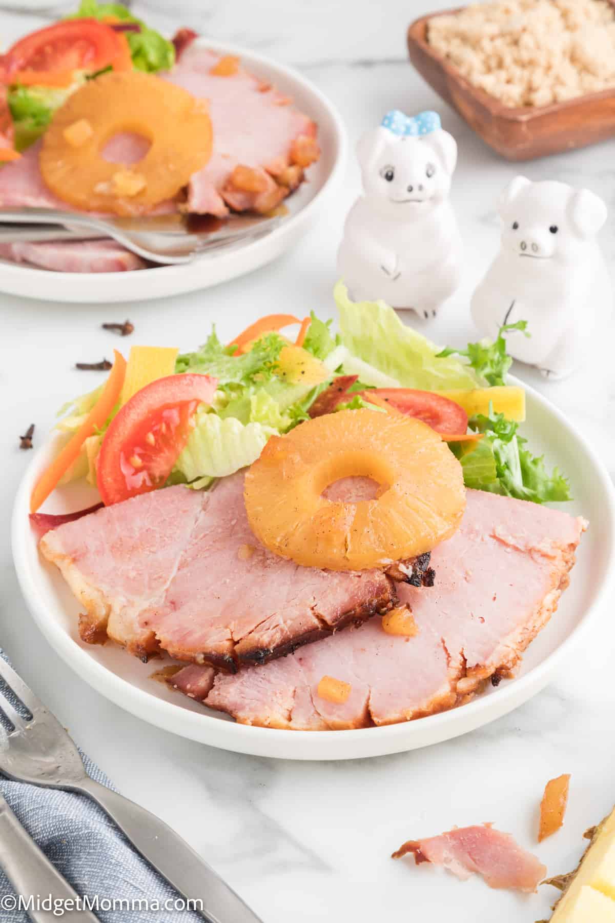 Baked Ham with Pineapple and Brown Sugar Glaze on a plate being served with a fresh salad