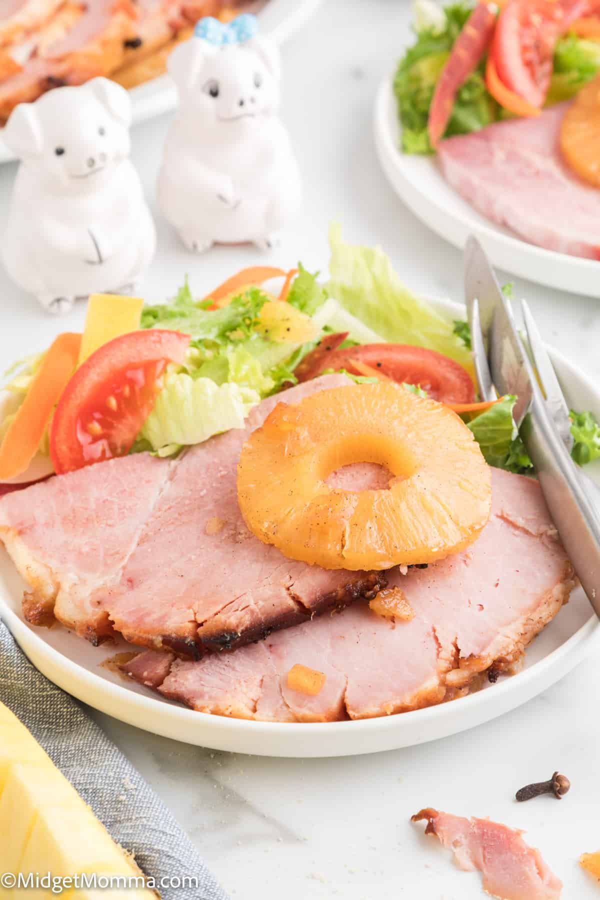 close up photo of baked ham on a plate with a salad