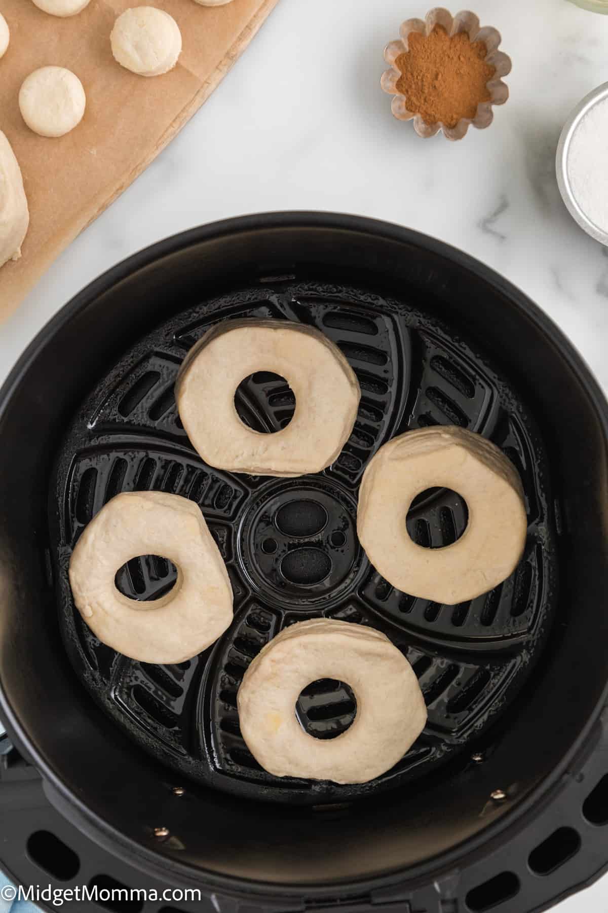 canned biscuit dough in air fryer basket to make air fried cinnamon donuts