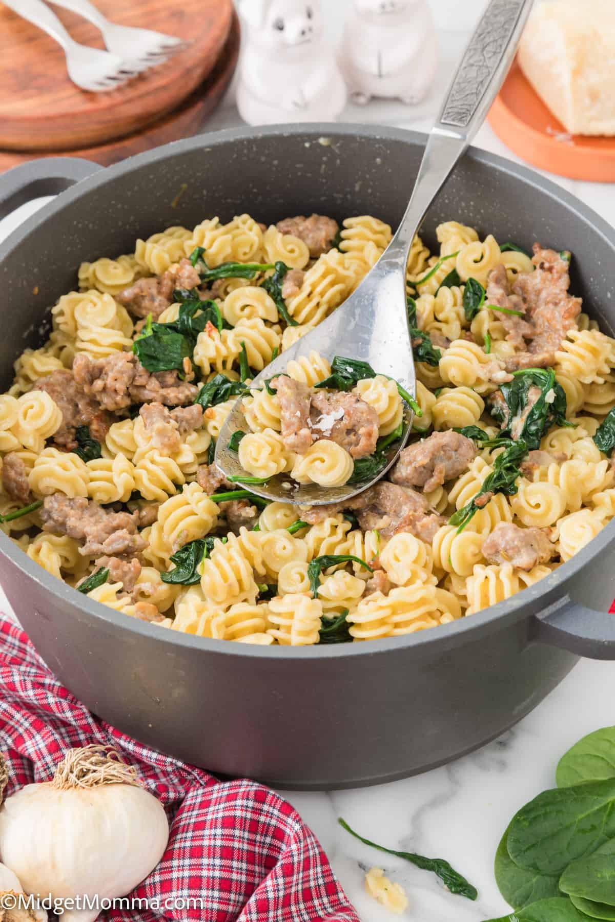 large pasta pot with Creamy Spinach Sausage Pasta and a spoon