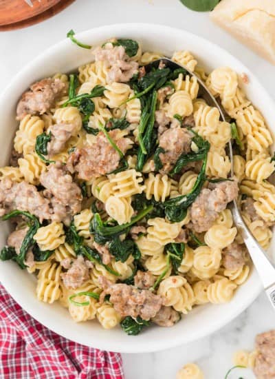 overhead photo of Creamy Spinach Sausage Pasta in a white bowl