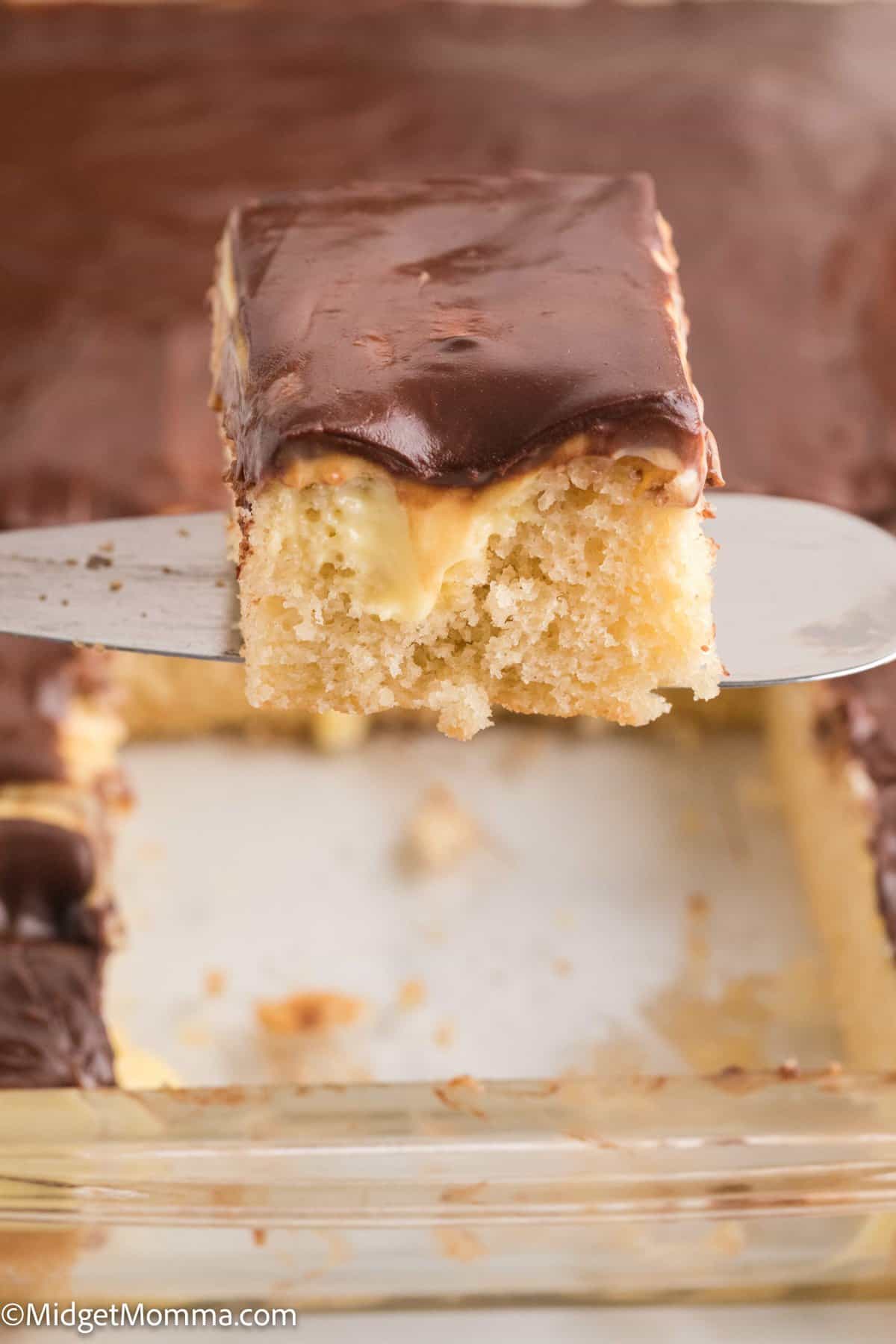 slice of Boston Cream Pie Poke Cake on a serving utensil