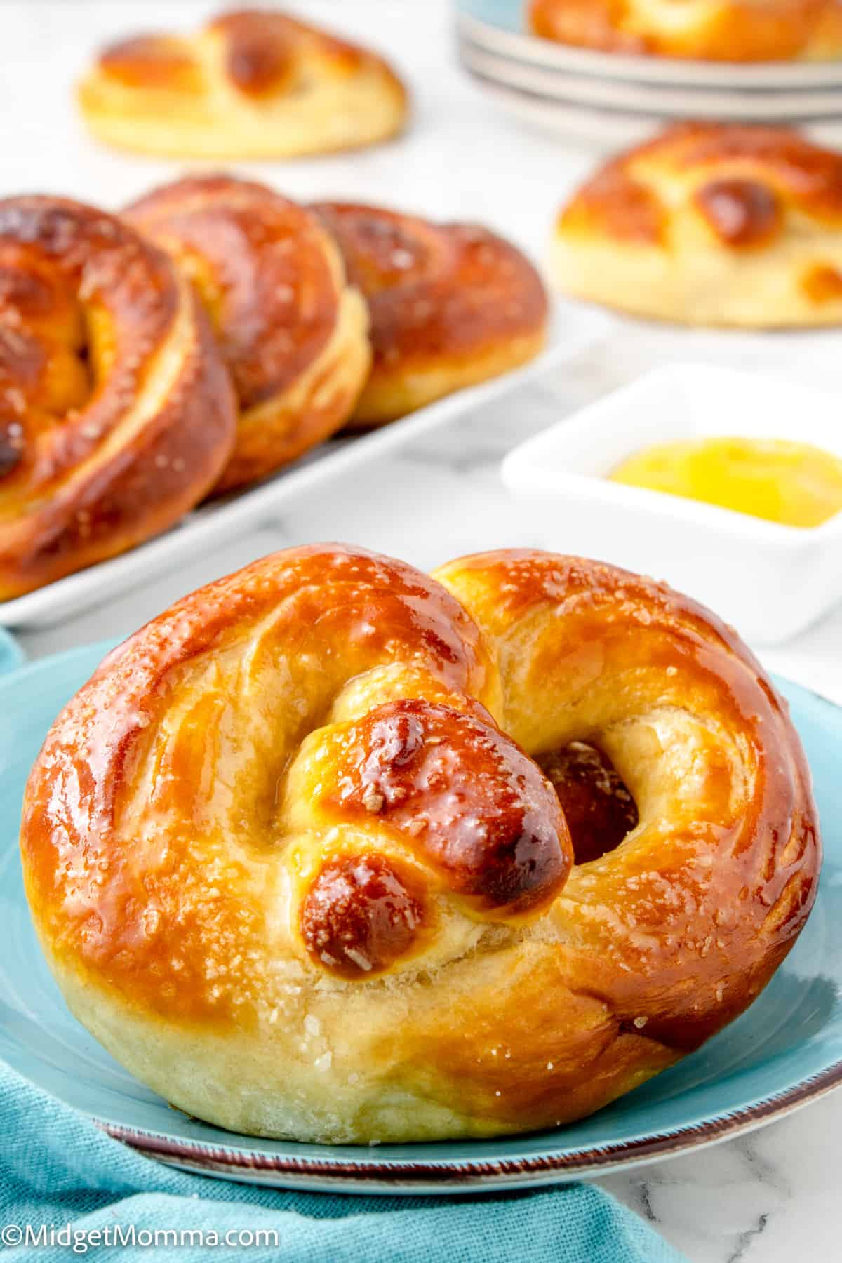 close up photo of a homemade soft pretzel on a plate