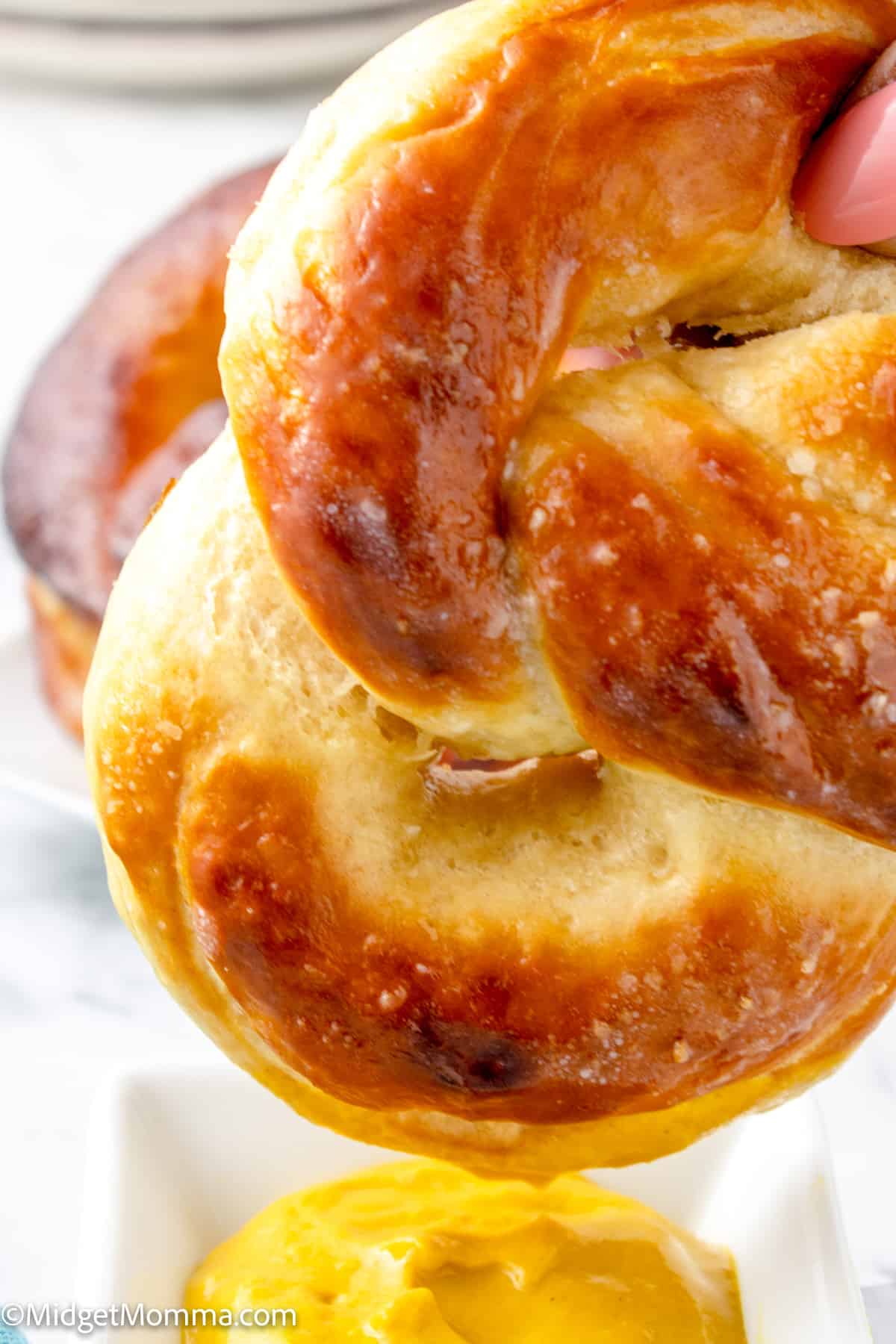 Homemade Soft Pretzel being dipped in mustard