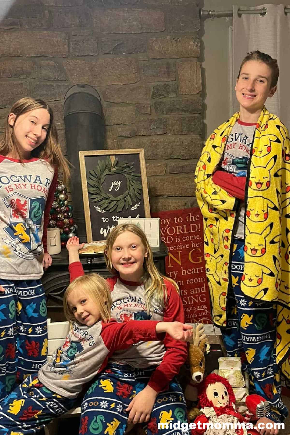 A family in christmas pajamas posing in front of a fireplace.
