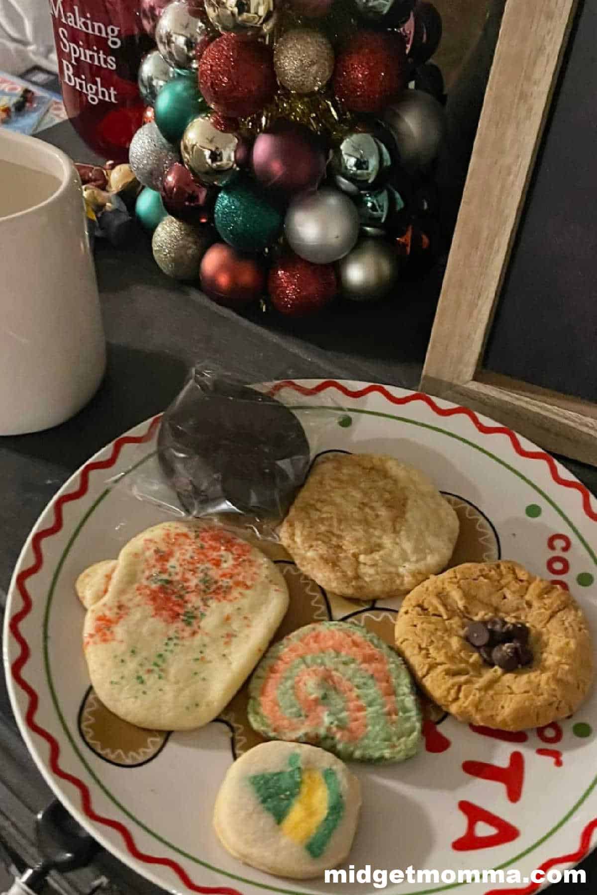 Christmas cookies on a plate with a cup of milk.